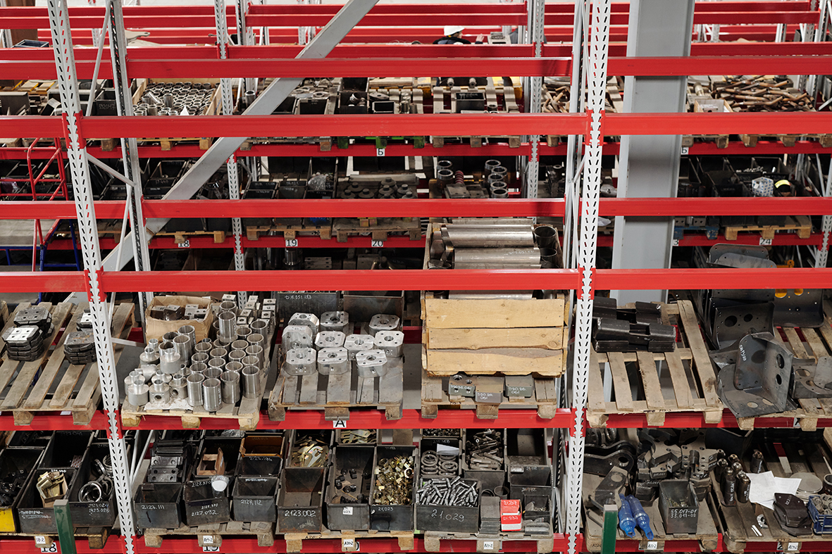 Part of spacious distribution warehouse of industrial plant with shelves full of spare parts for machines and repairing work